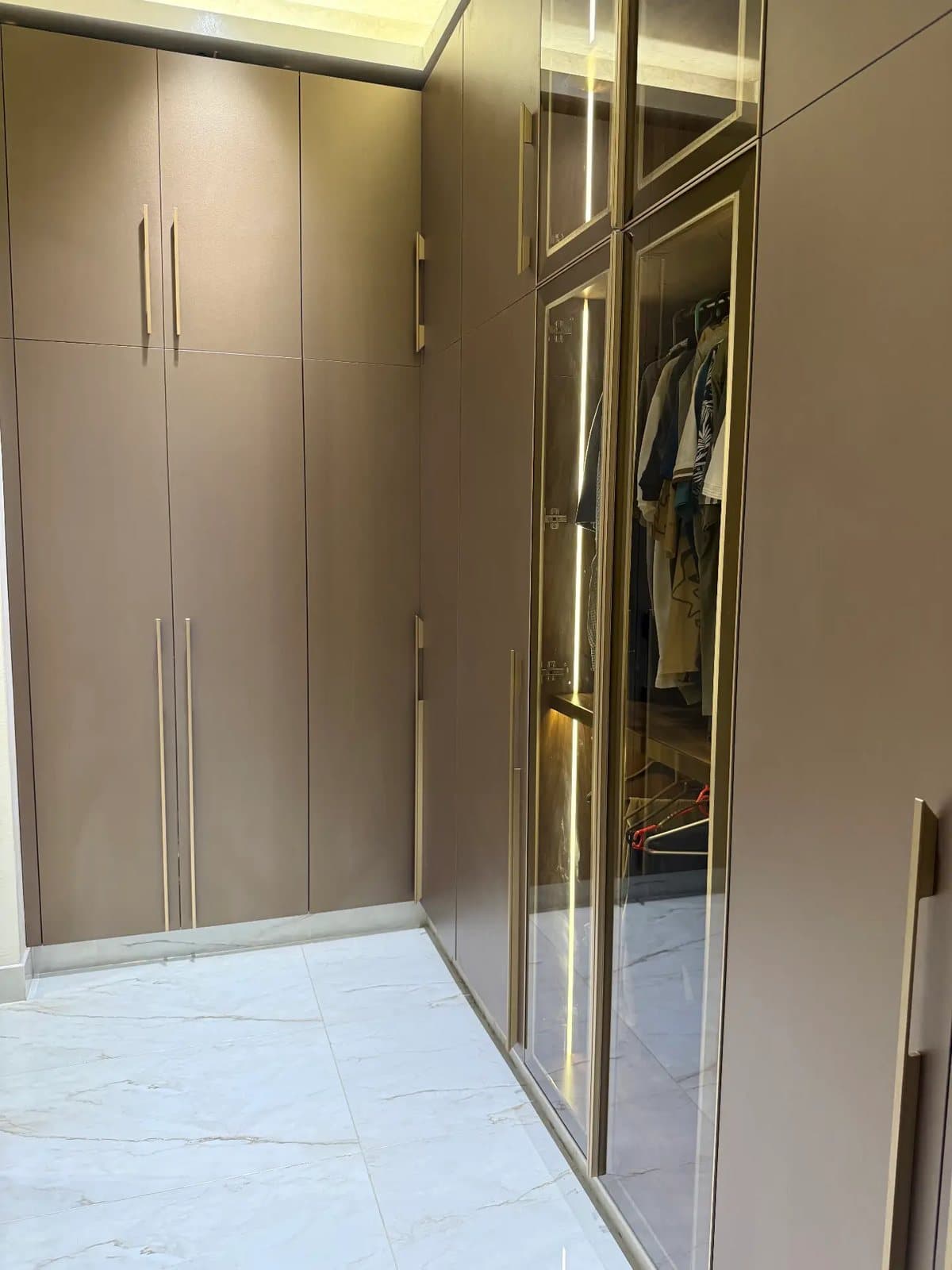 Brass wardrobe corridor by Amaza Homes